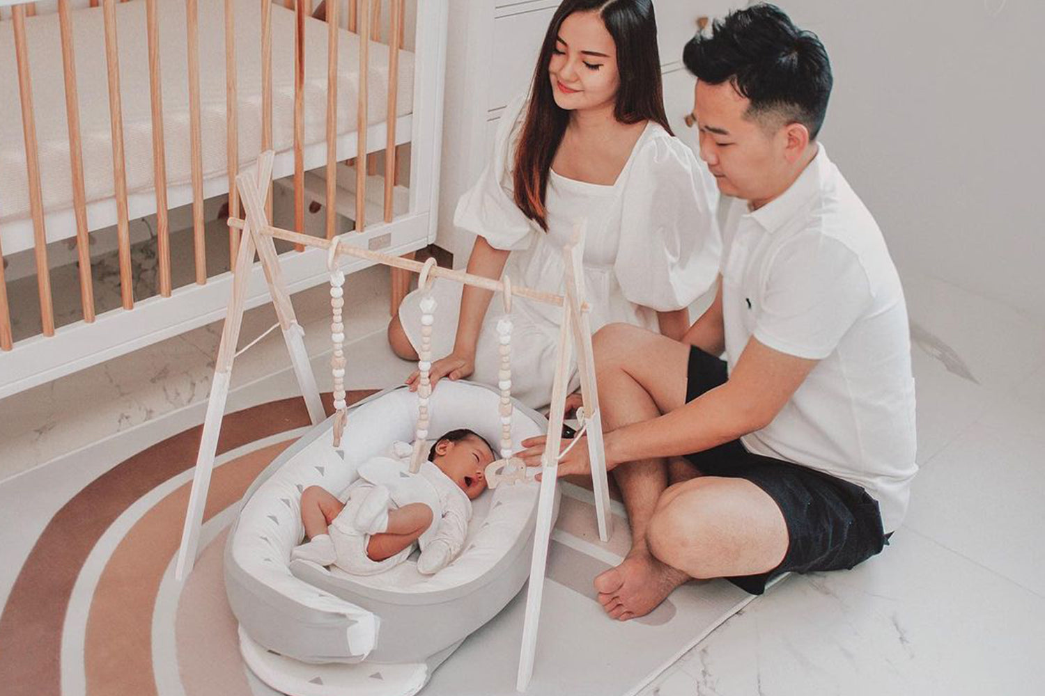 father and mother looking over baby napping