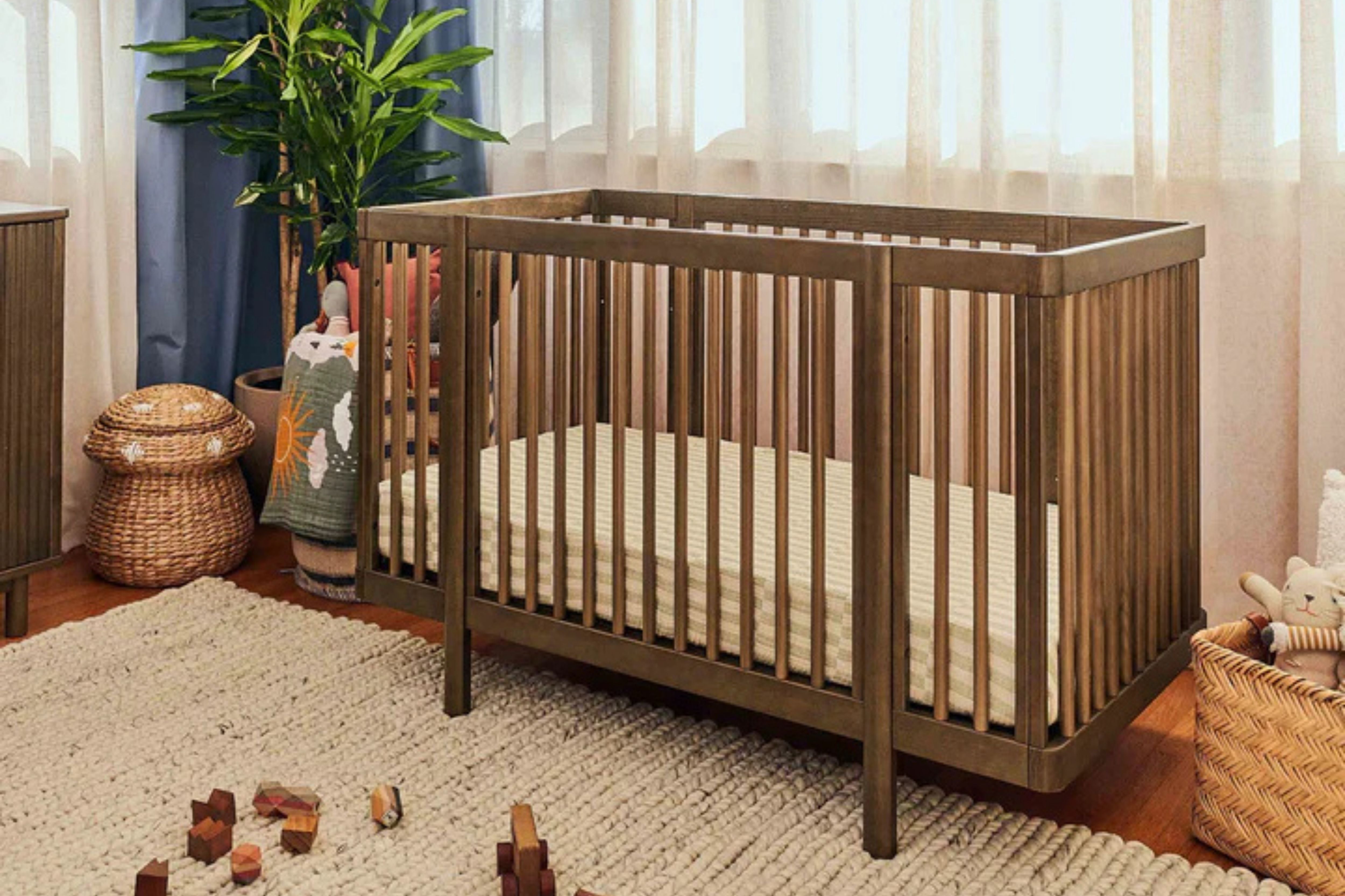 Babyletto natural walnut pogo 8-in-1-convertible crib full size crib displayed in a corner of the nursery#color_walnut