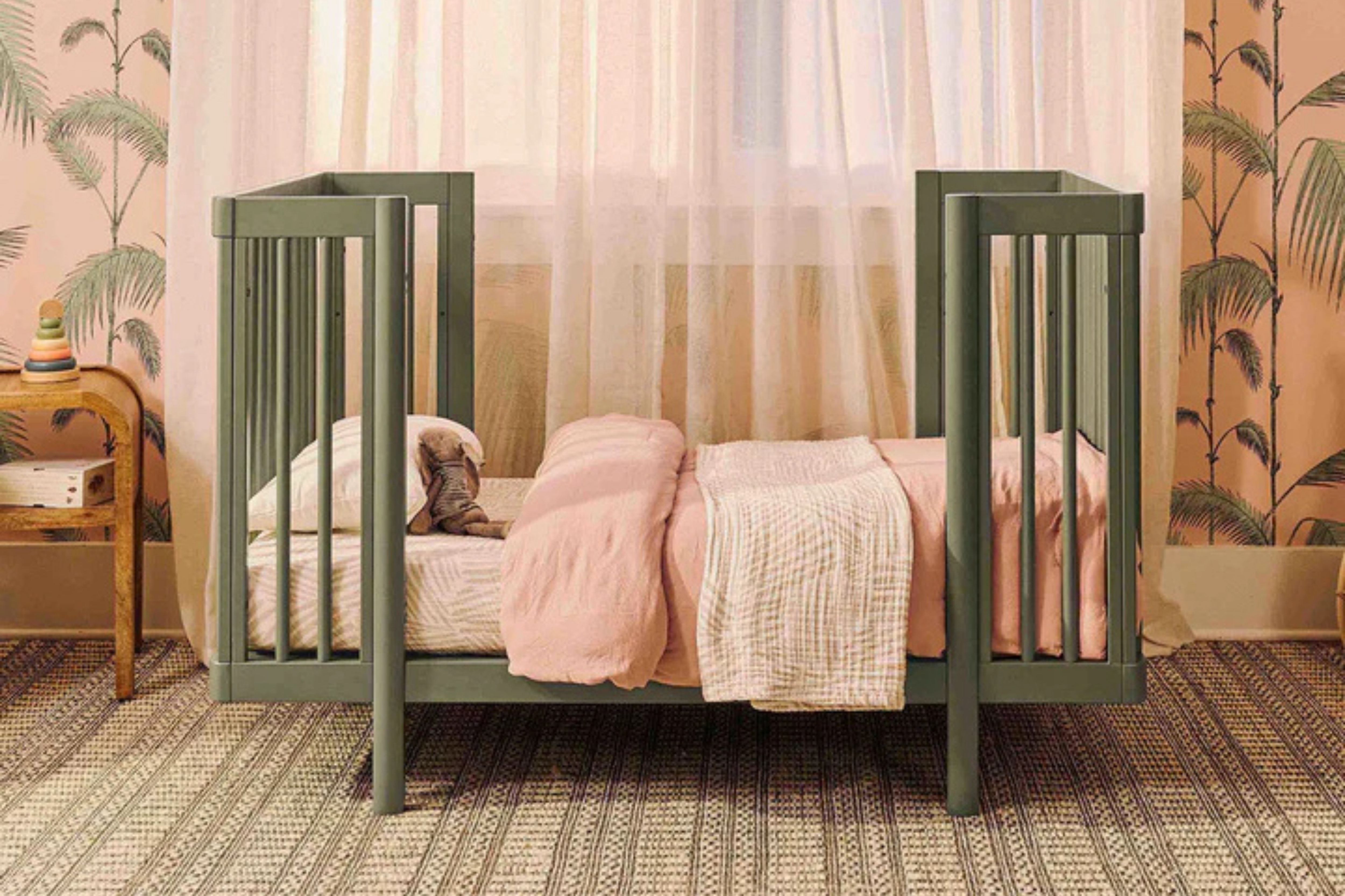 Babyletto olive pogo 8-in-1-convertible crib junior bed placed in a nursery#color_olive