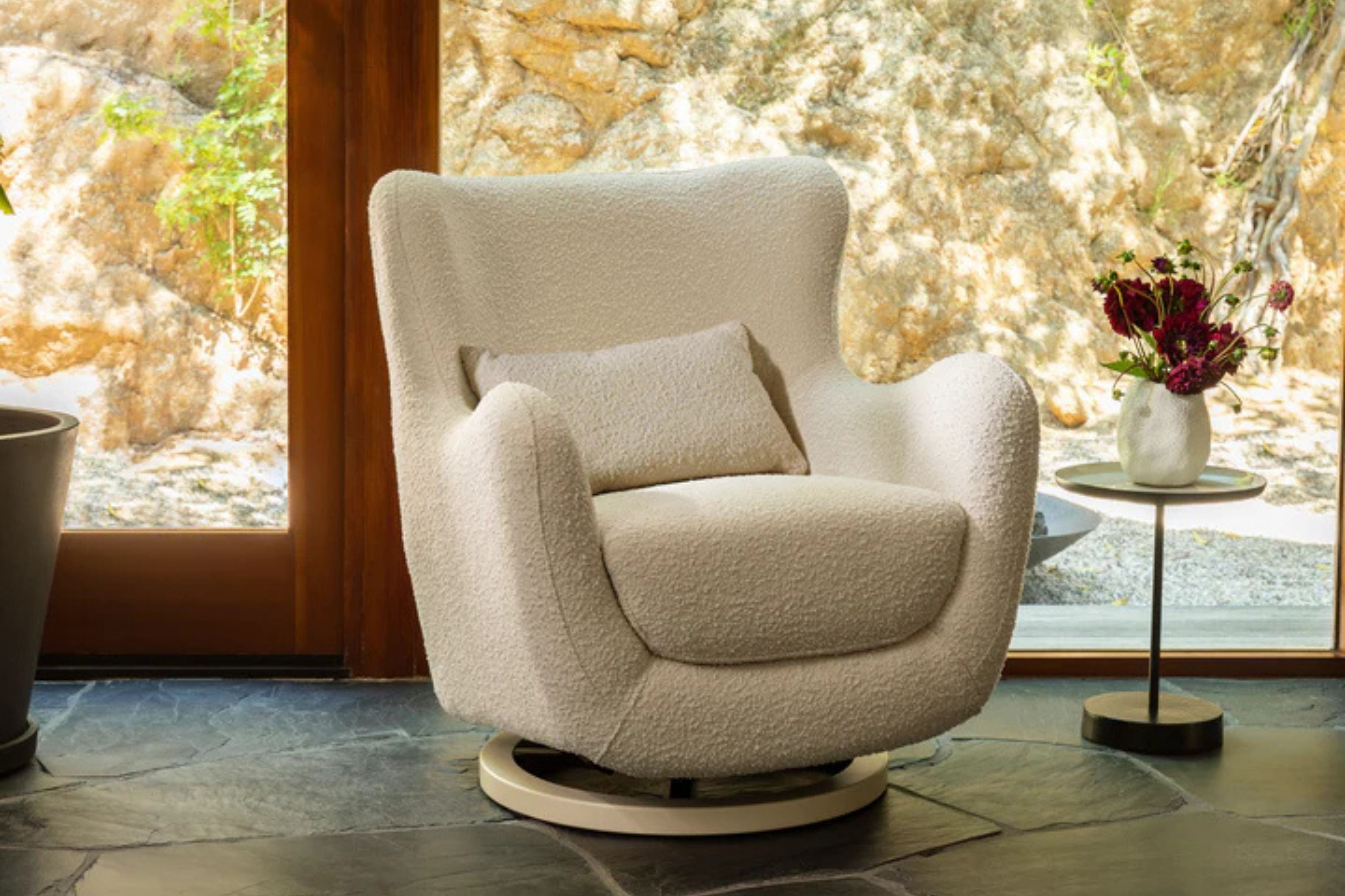 Nursery works solstice swivel glider ivory boucle displayed in a room#color_ivory-boucle-with-ivory-wood-base