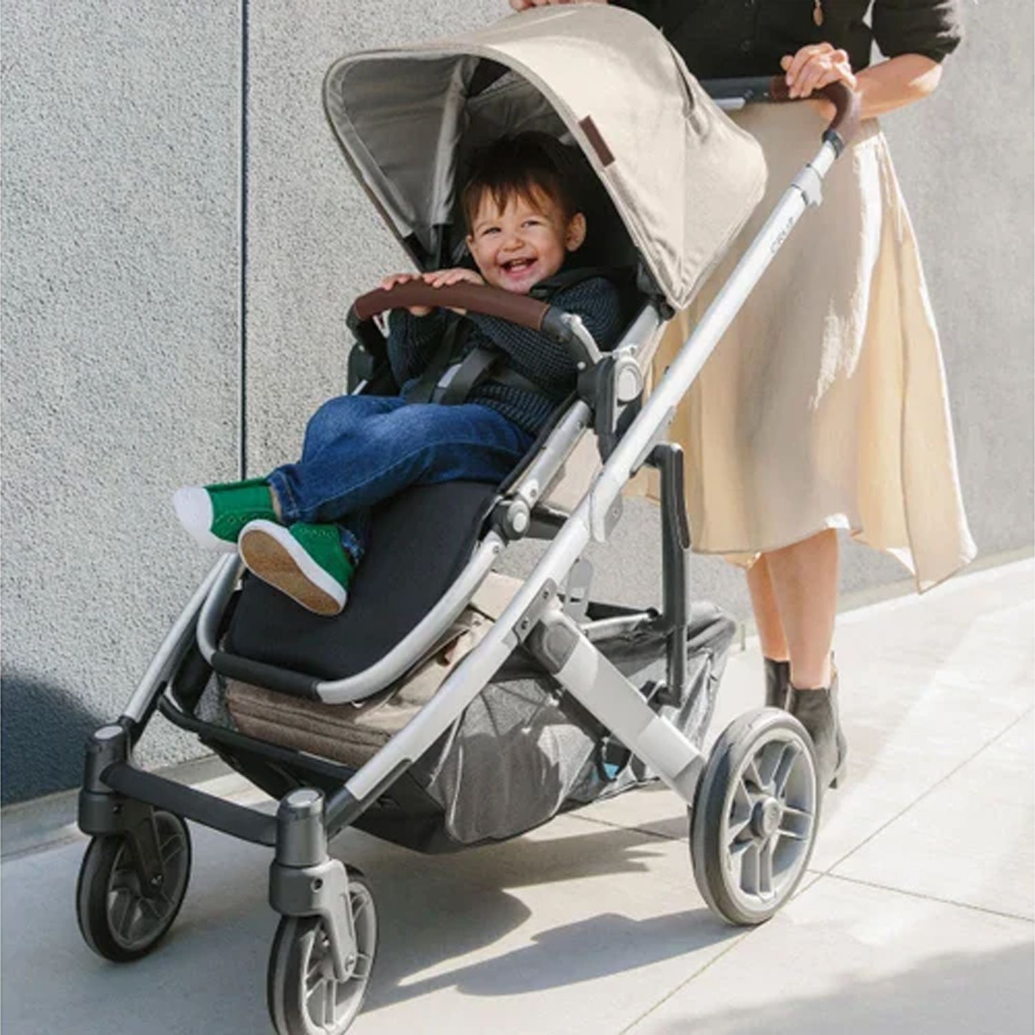 Baby laughing and sitting comfortably in the Uppababy Cruz 2 Declan Reversible Stroller