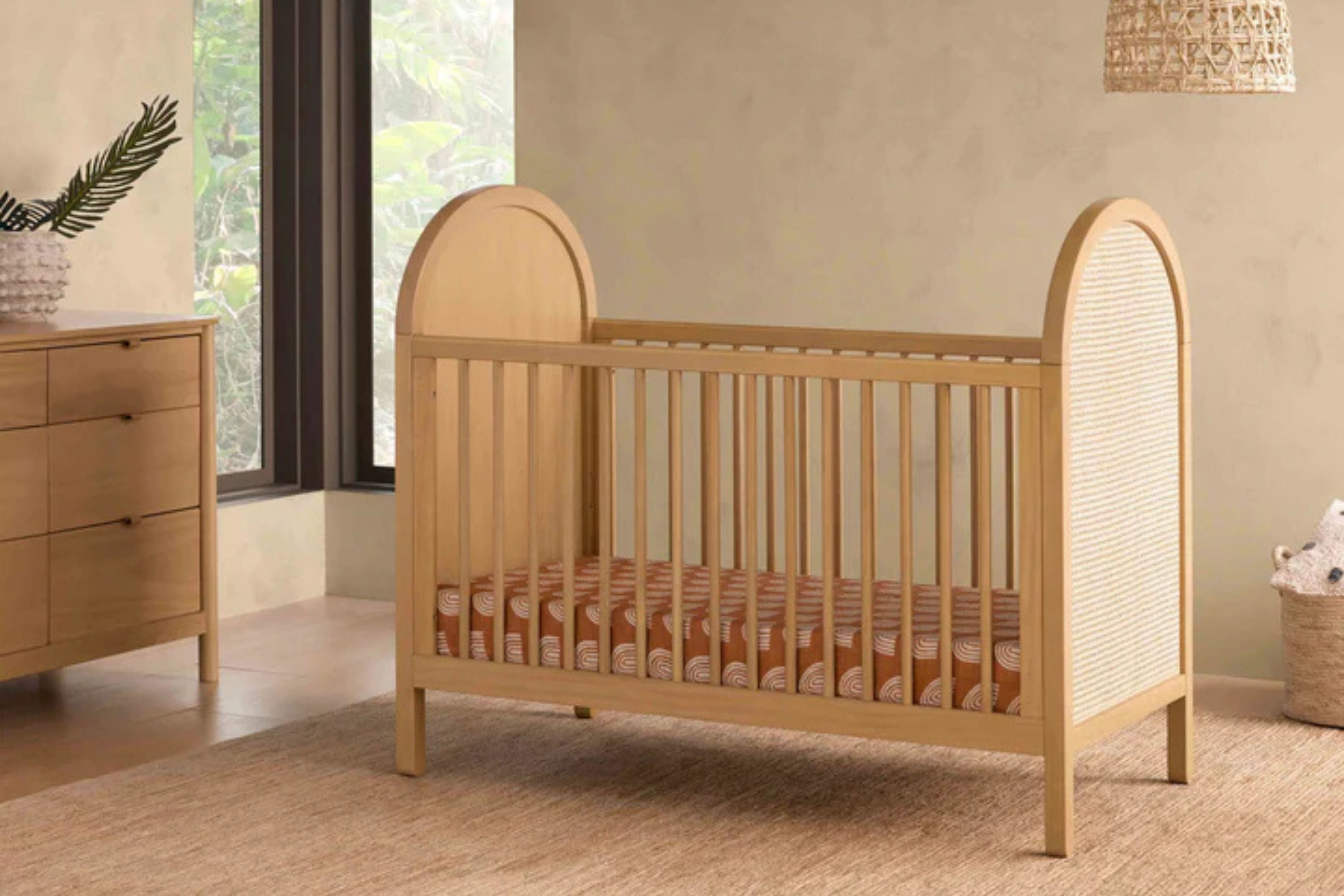 Babyletto Bondi Convertible Crib In Honey with natural cane displayed in a nursery#color_honey-with-natural-cane