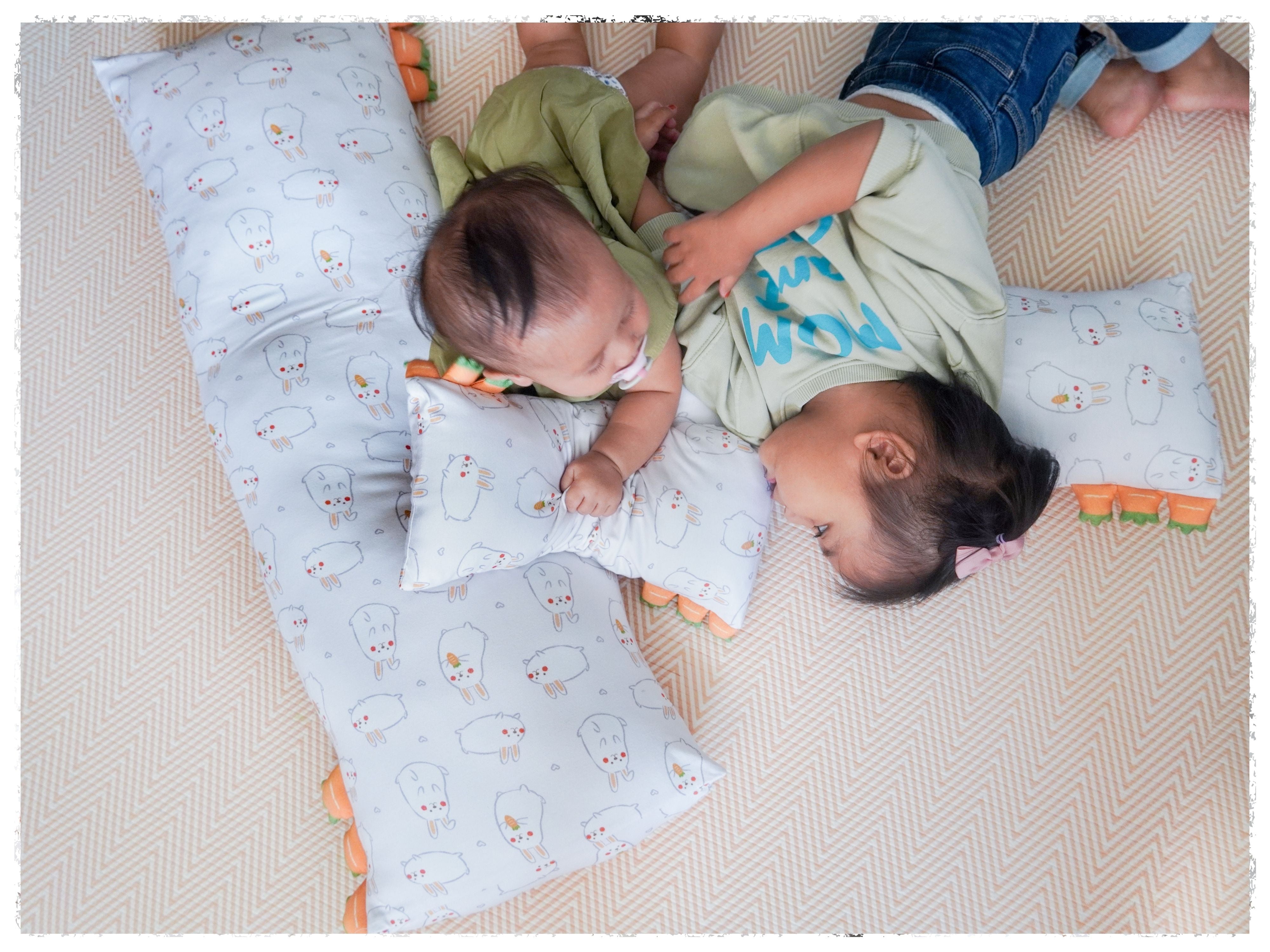 siblings lying around with some cho momo bunny pillows