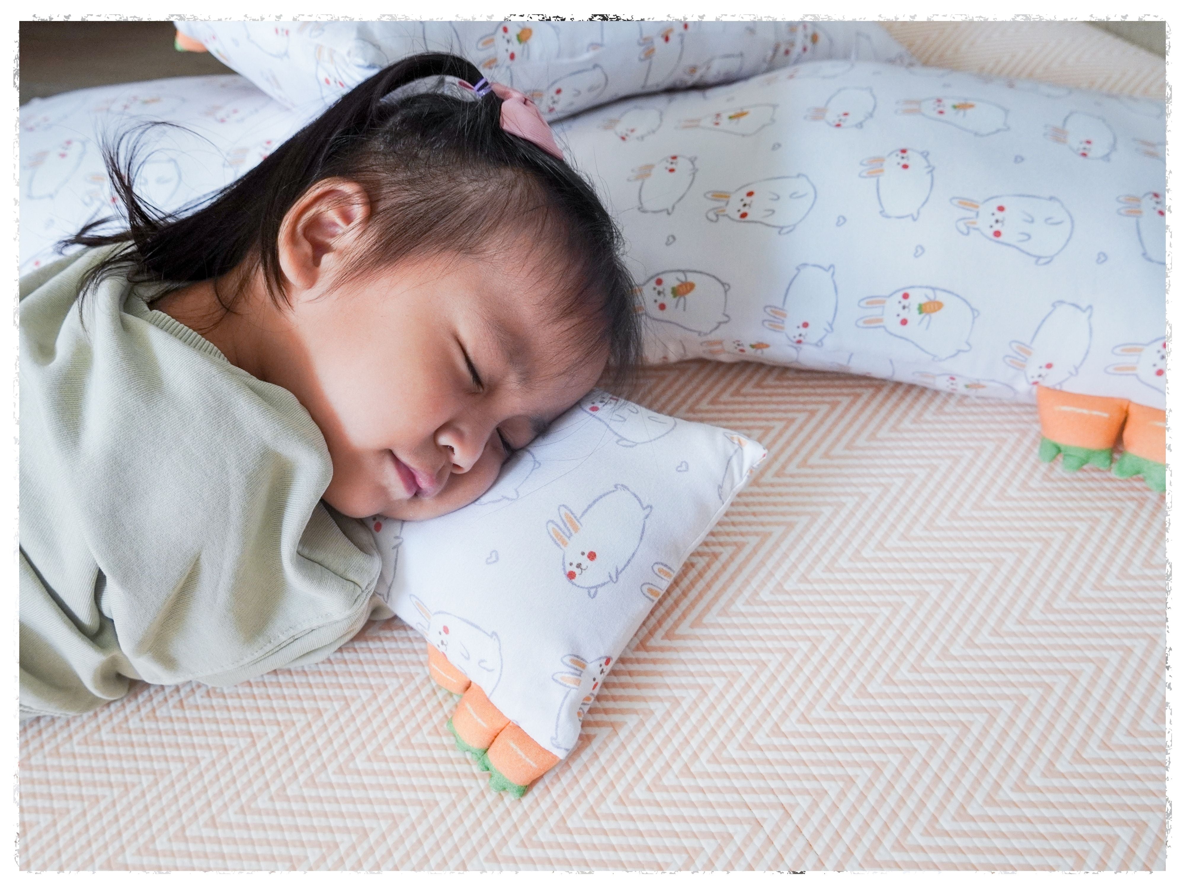 toddler sleeping on a small cho momo bunny pillow