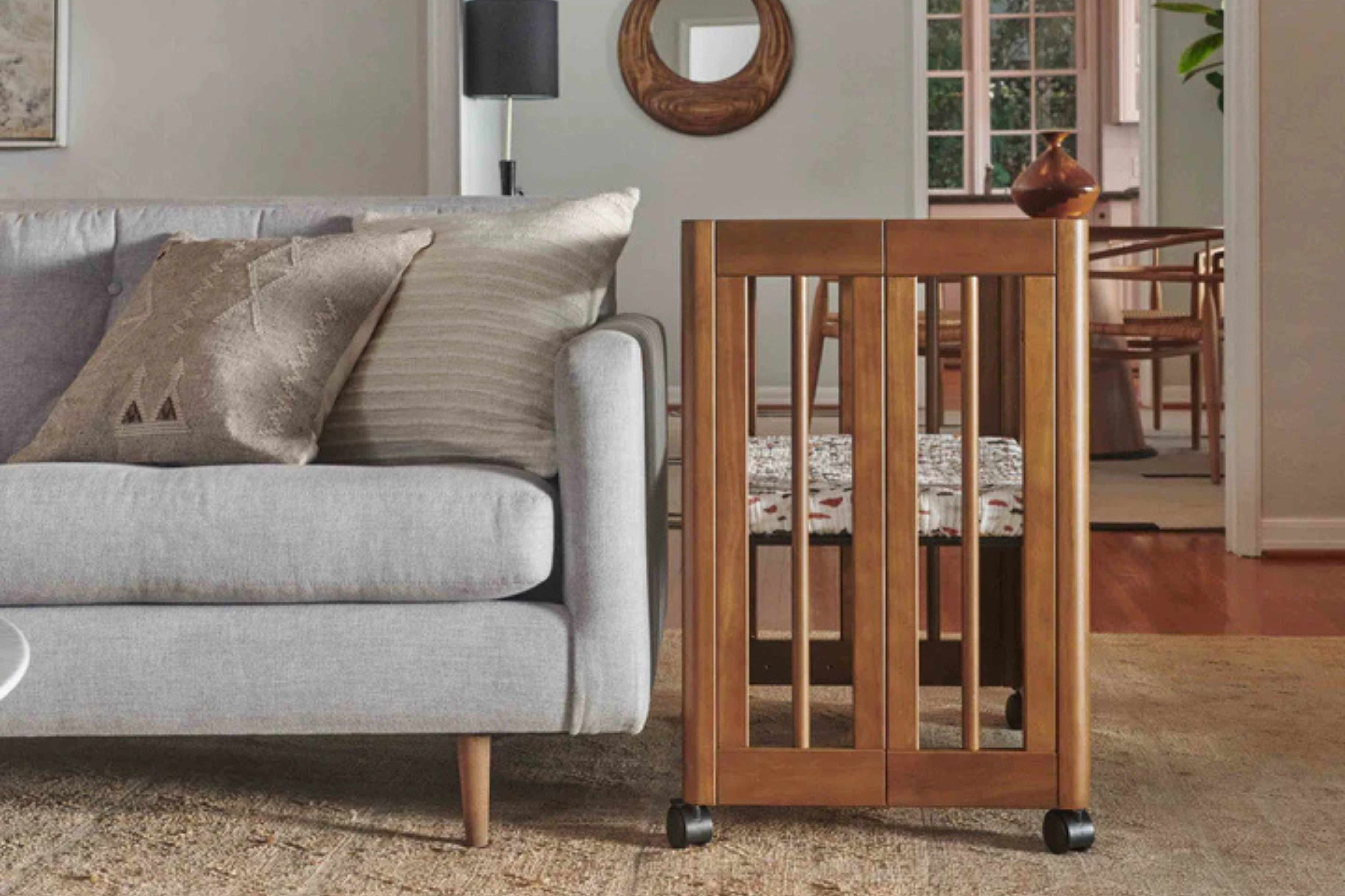 Babyletto Yuzu 8-in-1 Convertible Crib Walnut bassinet configuration in the living room, next to the sofa#color_walnut